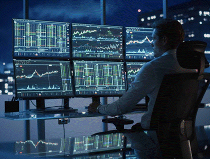 CIO at a multi-monitor trading desk analyzing market data at night
